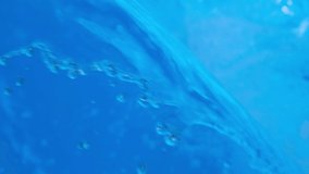 Sparkling overflowing blue transparent water in hot tub or swimming pool. Video banner full HD resolution. Decorative jet or waterfall of water in the pool. Slow motion video