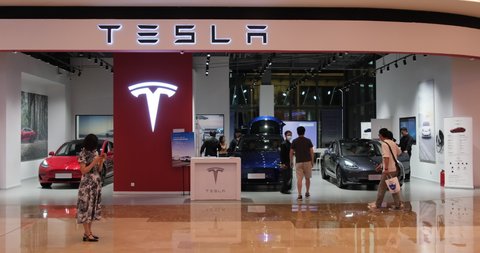 Shanghai.China-July.2021: Chinese customer walking into Tesla electric car store. Facade of Tesla EV store. Tesla is an American electric vehicle company 