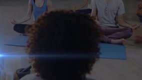 Animation of glowing light over people practicing yoga. fitness and healthy lifestyle concept digitally generated video.
