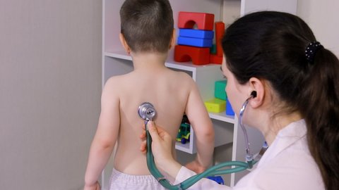 The pediatrician will auscultize the lungs and heart of a little boy 3-4 years old. Pediatrics, home-based doctor's appointment.