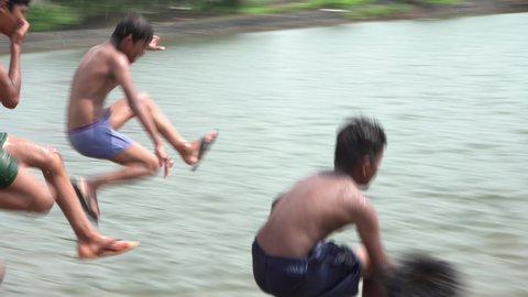 Indian kids jumping in the water, Mumbai, India, 04 July 2021
