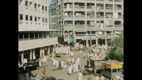 1970s: Students of Brahmin Caste. Man in turban from 2nd caste. Man from 3rd caste sells fruit at market. Man in 4th caste sweeps dust. Man washes stone steps. Busy urban scene. Boys play cricket.