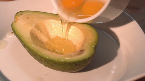 the chef pours quail eggs into half an avocado