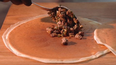 the chef wraps fried minced meat with mushrooms in pancakes