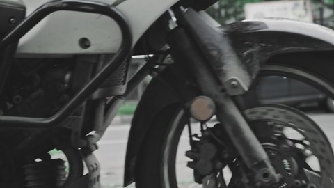 Super slow motion, white enduro motorcycle sweeps by against the backdrop of an urban landscape. The city landscape, asphalt and stones. Concept of travel, leisure sports and hobbies