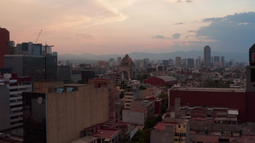 Forwards reveal and tilt down footage of famous Monument to Revolution on Plaza de la Republica. Historic landmark at twilight time. Mexico City, Mexico.