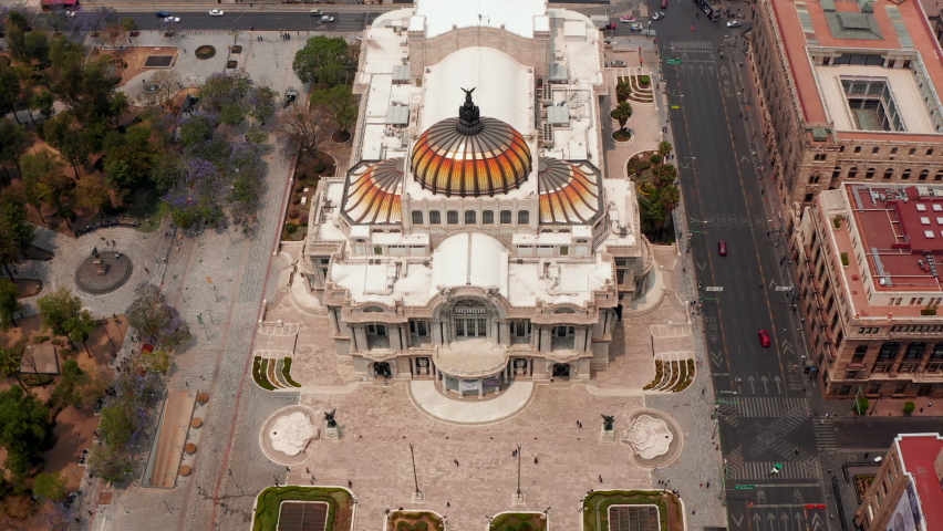 Forwards fly aerial shot of Palace of fine arts (Palacio de Bellas Artes) with colourful dome in historic part of city. Mexico City, Mexico.