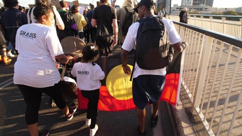 BRISBANE, QUEENSLAND, AUSTRALIA. JUNE 06 2020. Young family hold Aboriginal flag at BLM rally in Brisbane.