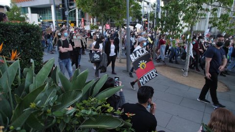 BRISBANE, QUEENSLAND, AUSTRALIA. JUNE 06 2020. Vaping smoker watches Black Lives Matter demonstration, with sound.