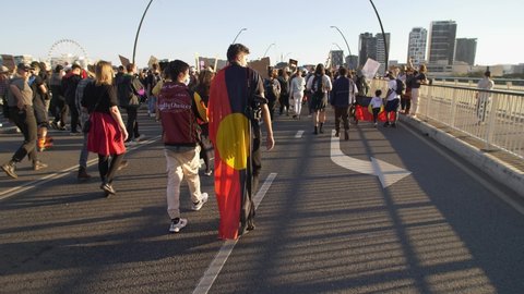 BRISBANE, QUEENSLAND, AUSTRALIA. JUNE 06 2020. Slow motion Aboriginal flag on protestor at BLM rally in Brisbane.
