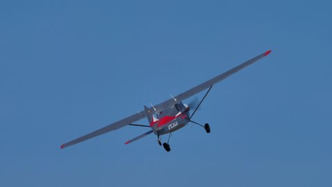 Ferrara Italy JUNE, 27, 2021 Vintage Cessna airplane in metal grey and red does a low and high speed pass over a grass strip in a sunny summer day. Cessna C170 D-ESCB built in 1957, during the 1950s.