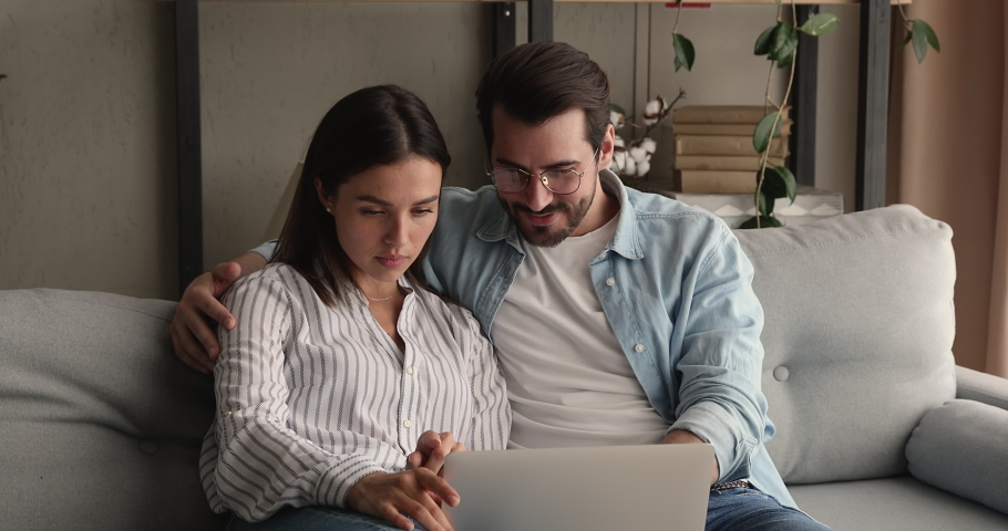 Bonding happy young family couple looking at laptop screen, reading email with amazing news, celebrating winning online lottery or giveaway, getting bank loan mortgage approvement, victory concept. Royalty-Free Stock Footage #1075713170