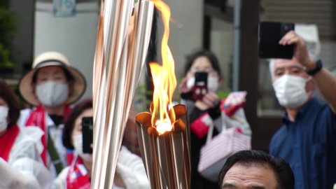 GOTENBA-SHI, SHIZUOKA, JAPAN - 25 JUNE 2021 : Tokyo 2020 Olympic Torch Relay at Gotenba-shi area. View of torch parade. Slow motion shot.