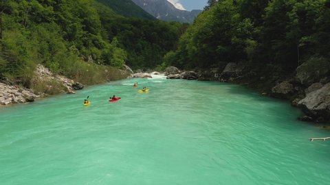 Aerial - Epic tracking shot of people whitewater kayaking on a beautiful turquoise river