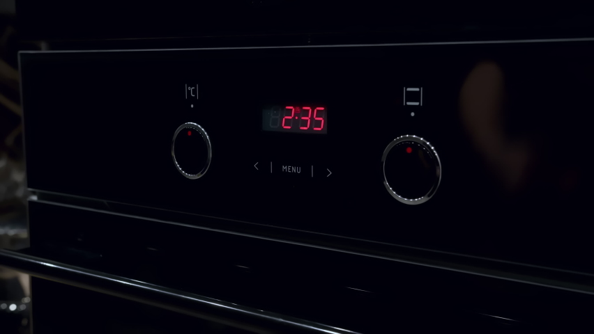 man turns on the oven for baking, cooking dinner at home in the evening, mooving camera, cinematic shot