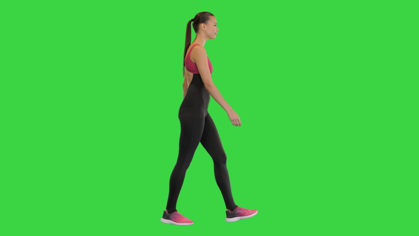 Happy healthy sporty girl walking on a Green Screen, Chroma Key.