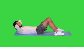 Handsome man exercising abdominal muscles on a Green Screen, Chroma Key.
