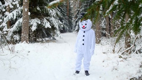 snowman kicks snow in winter snowy forest. Cheerful snowman. Christmas and New Year symbol. Winter holidays