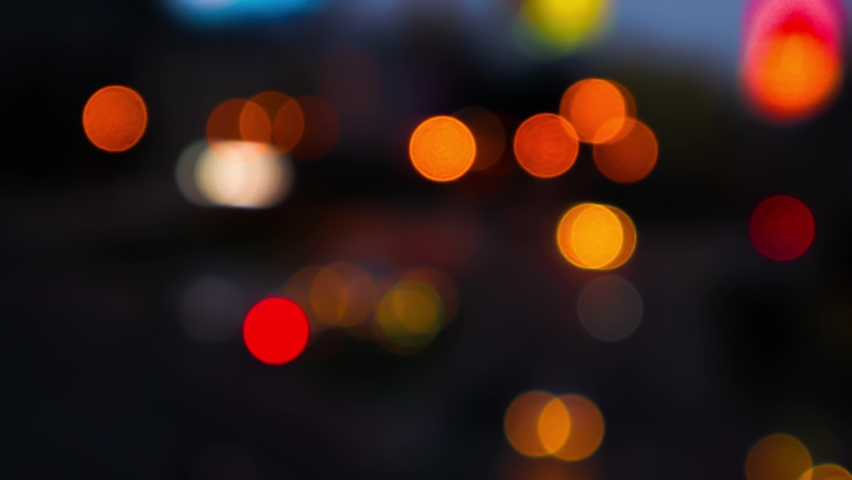 Night road lights blurred bokeh of cars in traffic on the road at night. Abstract bright blurred colored bokeh. Bokeh lights in the city night background Royalty-Free Stock Footage #1075728926