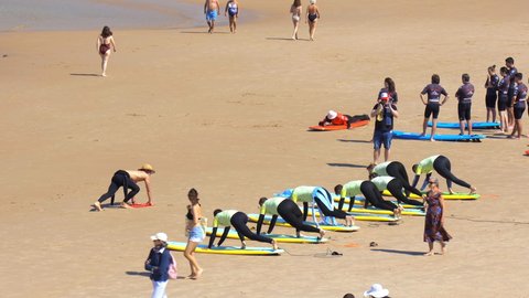 Biarritz, France - July 2021 : Bunch of friends learning to surf during a bachelor party on the Cote des Basques beach in Biarritz, France