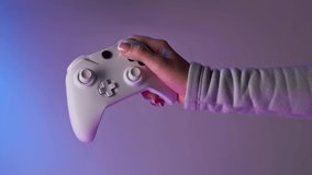 Hand with white gamepad on violet background. Bomerangs vertical video.