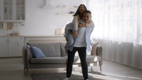 Happy Asian Couple Having Fun Dancing, Boyfriend Carrying Girlfriend At Home. Love And Romance, Weekend Leisure Concept. Slow Motion, Full Length Shot