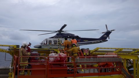 KELANTAN, MALAYSIA - OCT 22nd 2021: Slow motion footage of Weststar AW139 helicopter safely landed and helicopter landing crew waiting green light from pilot to enter landing zone.