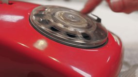 Dialing numbers on old red retro rotary phone, closeup. - Powered by Shutterstock - Get 15% off with code: PIKWIZARD15