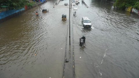 MUMBAI-INDIA- JULY 5, 2020: Commuters drive through a flooded street during heavy rains in Mumbai.