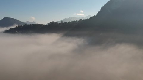 Aerial view of Itaipava, Petrópolis. Early morning with a lot of fog in the city. Mountains with blue sky and clouds around Petrópolis, mountainous region of Rio de Janeiro, Brazil.
