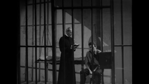 CIRCA 1941 - In this crime movie, a priest reads from Psalms as he walks with a convict from his prison cell to the execution chamber.
