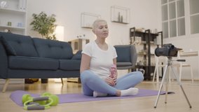 Slim mature lady shooting home workout video for beauty blog, lifestyle, hobby