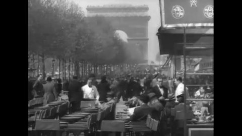 CIRCA 1930s - People eat at a sidewalk cafe on the Champs-Elysees in Paris, France.