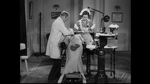 CIRCA 1932 - In this comedy movie, a dentist (WC Fields) uses a powerful tool on a woman's teeth.
