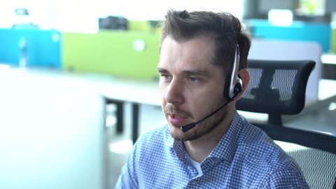 Male representative call center agent in wireless headset helping client, operator working in customer support service