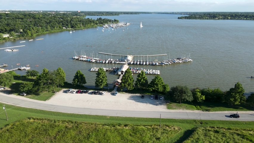 Aerial drone footage over sailboats and docks at White Rock Lake near downtown Dallas Texas during the day in summer