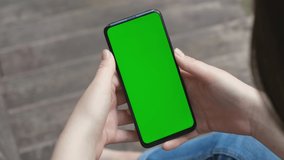 Back View of Woman at Phone with Green Screen for Copy Space. Chromakey Mock Up Without Tracking Markers. 20s Lady Watching Video News Close up. Tap to Click on Centre of Screen