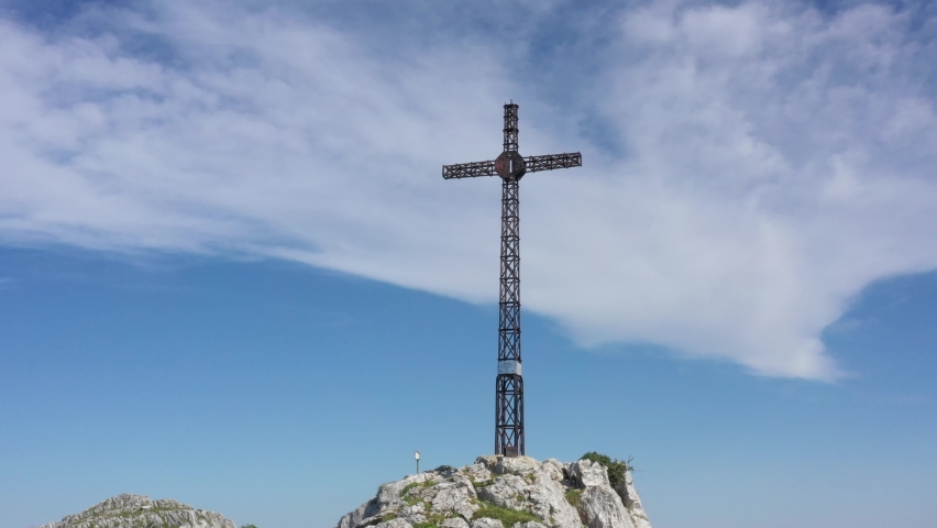 Aerial drone view of a large iron cross on top of a mountain in the Basque Country