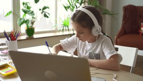 Girl study online with laptop, learning with video call and notebook. child writing note