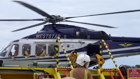 KELANTAN, MALAYSIA - OCT 22nd 2021: Unidentified Helicopter Landing Officer (HLO) and team unloading luggages from Weststar AW139 helicopter cargo area upon arrived at oil and gas platform.