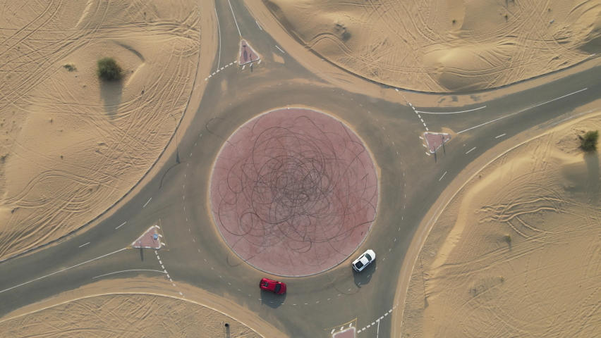 2 sports cars at the road roundabout around the uae desert
