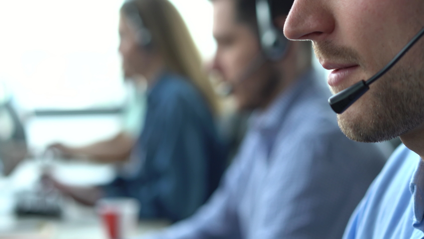 Male representative call center agent in wireless headset helping client, operator working in customer support service | Shutterstock HD Video #1075807478