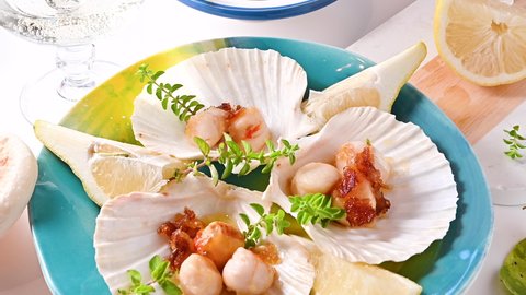 fried scallop, healthy gourmet food, seared scallops with caviar on on a beautiful dish in shellfish shells. A traditional dish of france and italy sea food. 