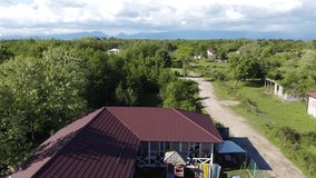 Aerial video from the drone. A wonderful landscape with a view of the village of Alakhydzy in Abkhazia and the Caucasus mountains on the horizon.