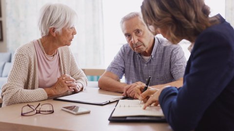 Senior man and woman meeting medical adviser for health insurance. Old couple planning their investments with financial advisor after retirement at home. Aged couple consulting with insurance advisor.