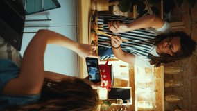 Video of young woman recording a video of her young professional chef while preparing pasta in the kitchen at home. Young couple on kitchen. She films him while talk about how to cook  family vlog