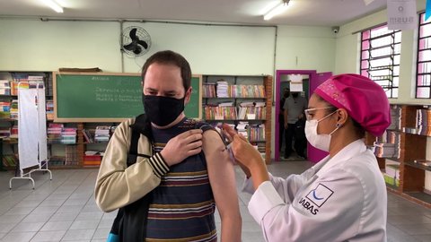 Sao Paulo, SP, Brazil - July 12, 2021: A nurse gives a shot of Janssen, Johnson and Johnson, COVID-19 vaccine to a man during a priority vaccination program for people with more than 37 years old.
