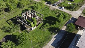 Aerial video from the drone. A wonderful landscape with a view of the village of Alakhydzy in Abkhazia and a textured abandoned ruined house from the war, overgrown with thickets of plants.