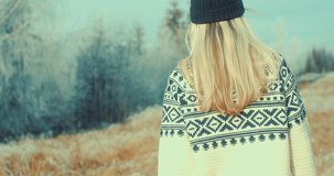 Woman traveler in beautiful winter snowy forest view. Fashion girl in wool sweater. Happy winter holidays. New Year's Eve. Christmas holiday. 4K video Slow motion.