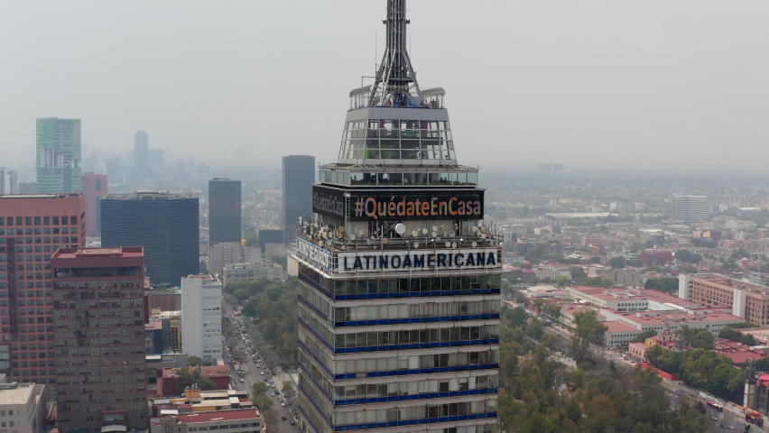 Backwards reveal of cityscape around Torre Latinoamericana tall building. Top of skyscraper with lookout platform. Mexico City, Mexico.